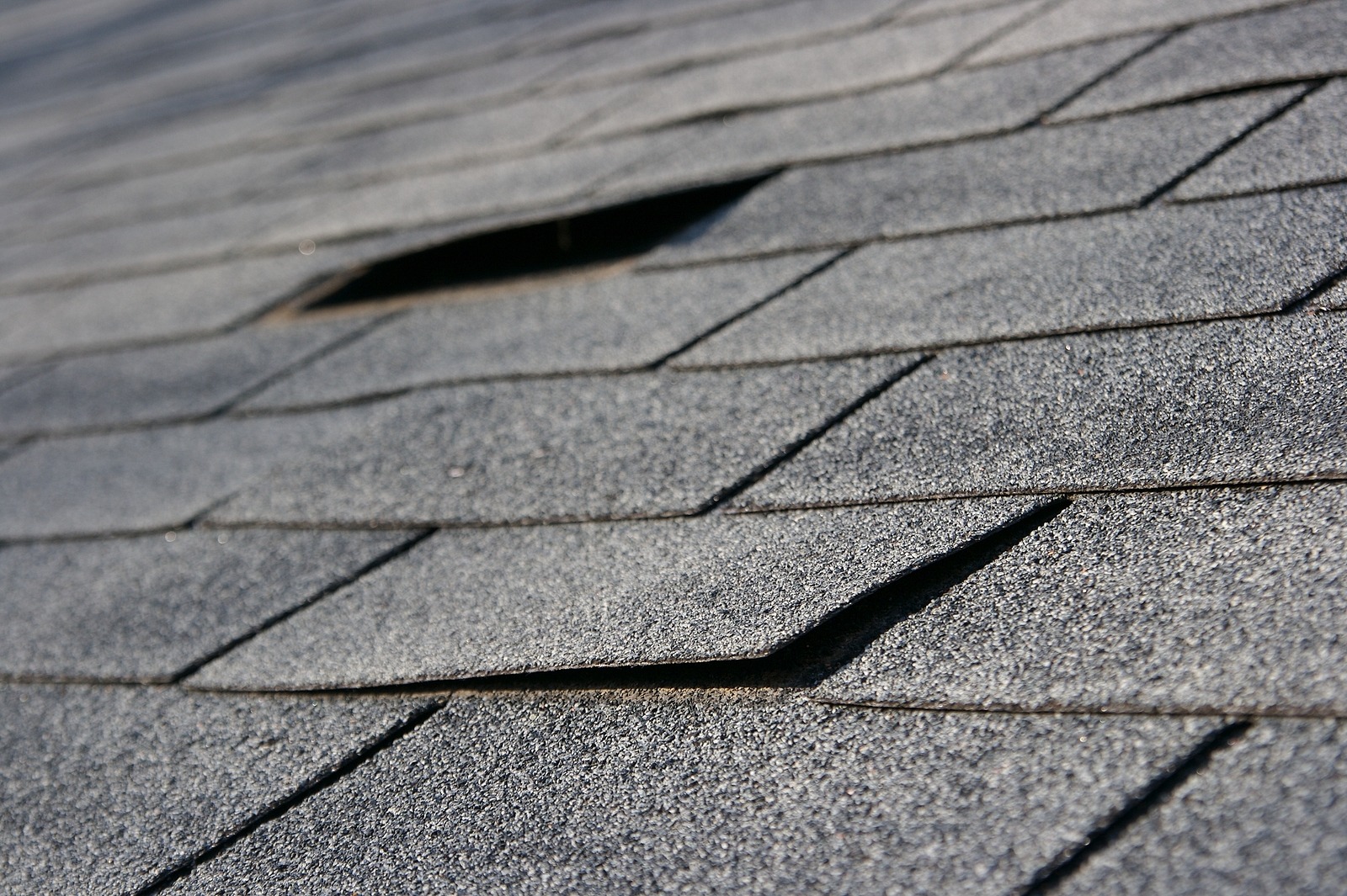 Roofing trouble - damage to shingles that needs repair - home maintenance series. Narrow DOF